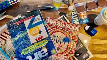 Zeitschriften liegen verstreut auf einem Tisch, Drinks nebenbei.