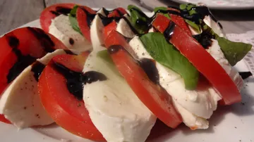 Tomaten und Mozzarella übereinander geschichtet, mit Balsamico.