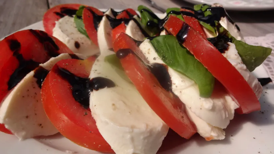 Tomatoes and mozzarella layered on top of each other, with balsamic vinegar.