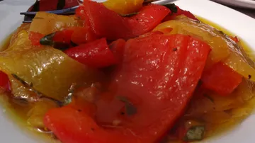 Bunte Paprika liegen in einer Schüssel mit Öl.