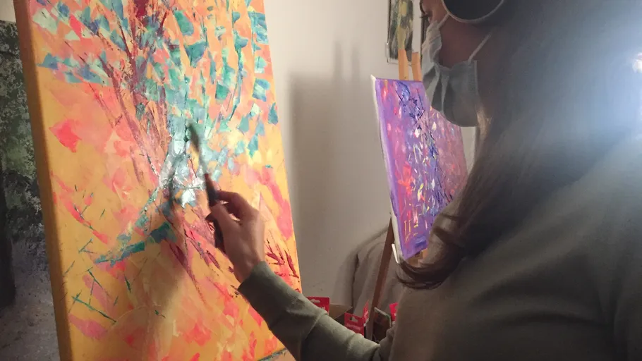 Person painting abstract art on canvas