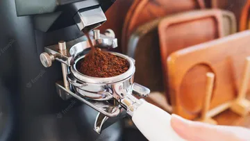 Coffee powder is filled into a portafilter in a kitchen.