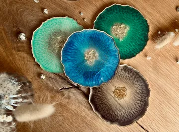 Colourful coasters lie on a wooden table.