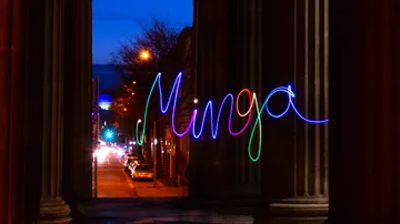 Colourful “Minga” light up between pillars at night.