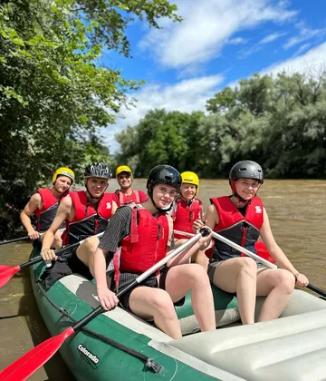 Group participants in canoes paddle on a river.
