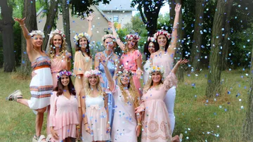 Group of young women celebrate with confetti in nature.