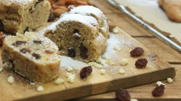 A piece of cake lies on a wooden board, surrounded by decoration.