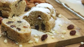 Sweet cake is lying on a wooden board, with powdered sugar.