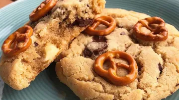 Cookies with chocolate chips and pretzels on a plate.