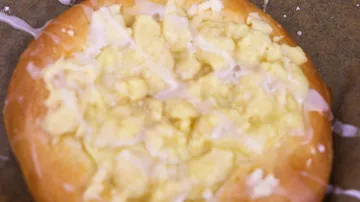 Kuchenstück mit üppigem, klebrigem Belag auf Blech.