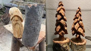 Wood carving of a gnome and tree sculptures.