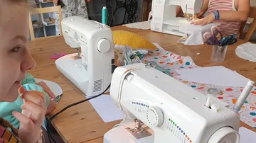 Two sewing machines on a table, creative work in progress