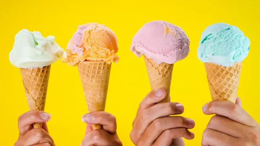 Four ice cream cones with different flavors on a yellow background.