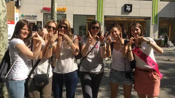A group of women forms a heart symbol with hands.