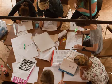 Gruppierung von Personen arbeitet an kreativen Projekten am Tisch.