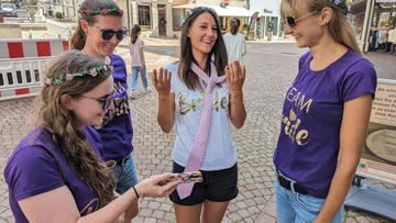 Vier Frauen feiern, lachen und präsentieren Geschenke in der Stadt.