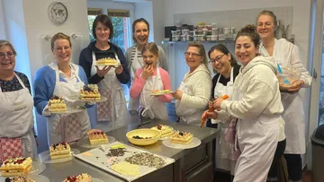Gruppen von Frauen backen Torten in einer modernen Küche.