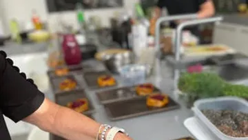 Kochende Person bereitet Gerichte in moderner Küche vor.