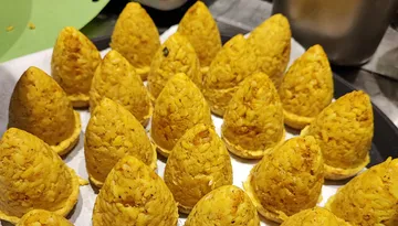 Yellow rice cones on a tray, freshly prepared.