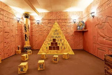 Pyramid with hieroglyphs in an Egyptian room.
