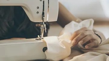 Nähmaschine näht Stoff in entspannter Umgebung.