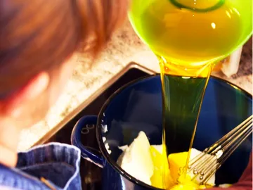Oil is poured into a bowl with ingredients.