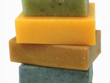 Four coloured soap substances are stacked on top of each other.