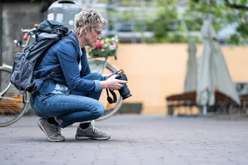 Person taking pictures on the ground in an urban environment.