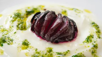 Rote Zwiebel in Joghurt, umgeben von grüner Sauce.