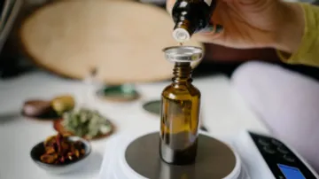 Braune Flasche wird mit einem Tropfer gefüllt, Tischumgebung.