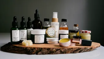 Nice bottles and pots arranged on a wooden board.