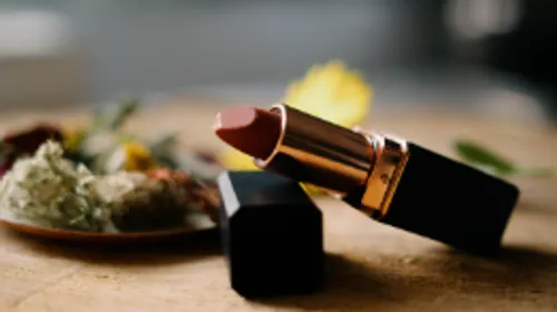 Lipstick on table with floral accents.