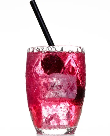 A drink in a glass with a black straw.