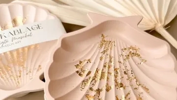 Pink mussel rack with gold accents on beige.