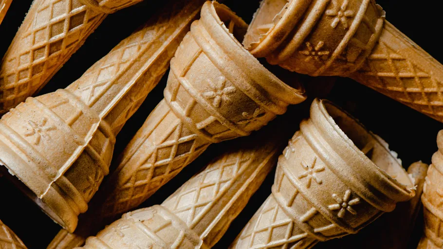 Ice cream cones lie unsorted on a dark surface.