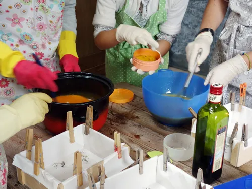 People use materials to make soap in a workshop.