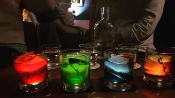 Bunte Cocktails stehen auf einem Tisch in einer Bar.