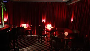 Dark red café with tables and chairs in the background.