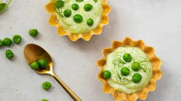Kleine Törtchen mit Erbsenfüllung auf grauem Hintergrund.