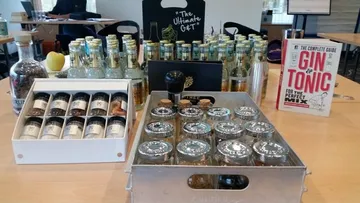 Flasche, Gläser und Zutaten für Gin und Tonic stehen bereit.