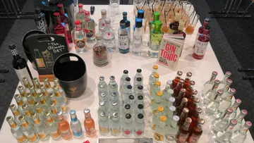 A bottle of drinks is on a table in a bar.