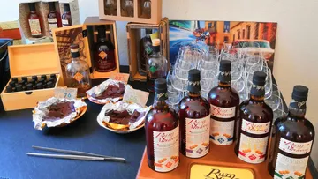 Bottles of rum stand next to chocolate and glasses.