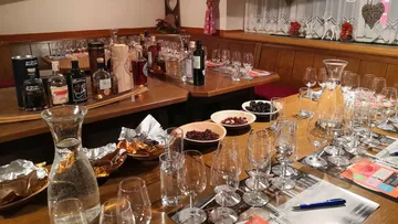 Tisch gedeckt mit Gläsern, Getränken und Snacks für Event.