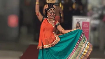 Dancer in traditional dress performs an expressive dance.