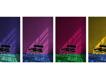 Chair stands in front of colorful walls with shadows.