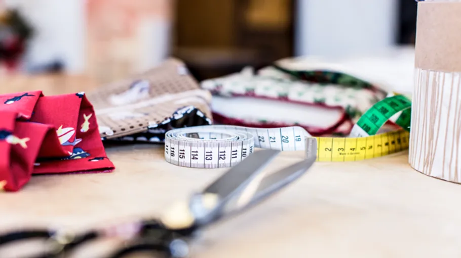Tailor's tools and fabrics on a table ready to sew