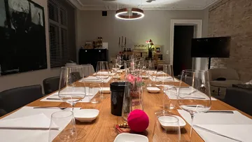 Ein gedeckter Tisch mit Gläsern und Servietten in einem Raum.