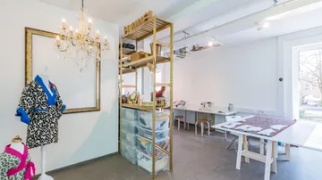 Fashion studio with tailor's doll, chandelier and workplaces.