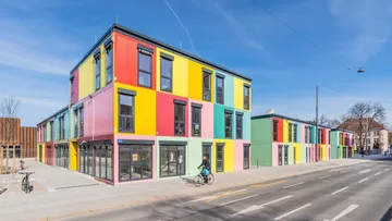 Buntes Gebäude mit Fenster, Fahrrader von der Straße fahren.
