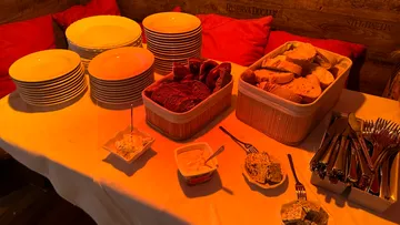 Plate and bread on a table against a red background.